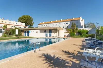 a swimming pool in front of a building at Duplex T2 com terraço e BBQ em Vilamoura in Quarteira