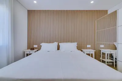 a bedroom with a large white bed with two tables at Mar Azul 2 Bdr Apartment Quarteira in Quarteira