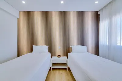 two beds in a room with a striped wall at Mar Azul 2 Bdr Apartment Quarteira in Quarteira