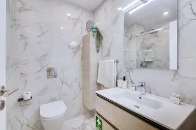 a white bathroom with a sink and a toilet at Mar Azul 2 Bdr Apartment Quarteira in Quarteira