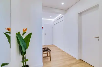 a hallway with white walls and a door and a plant at Mar Azul 2 Bdr Apartment Quarteira in Quarteira