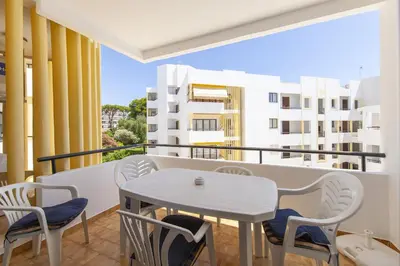a table and chairs on a balcony with a view of buildings at A02 - Casa Topazio in Quarteira in Quarteira