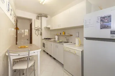 a kitchen with white cabinets and a white refrigerator at A02 - Casa Topazio in Quarteira in Quarteira