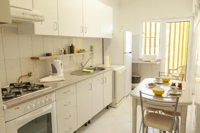 a white kitchen with a sink and a stove top oven at A02 - Casa Topazio in Quarteira in Quarteira