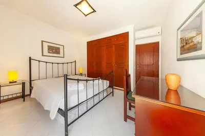 a bedroom with a bed and a dresser in it at A02 - Casa Topazio in Quarteira in Quarteira