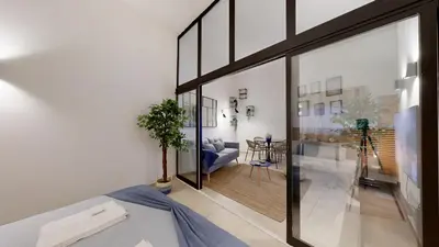 a living room with large glass windows and a couch at Apartamento T0 MFA, 400m Praia dos Pescadores in Albufeira