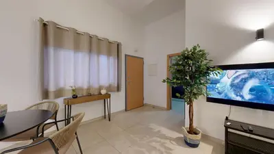 a living room with a dining table and a tv at Apartamento T0 MFA, 400m Praia dos Pescadores in Albufeira