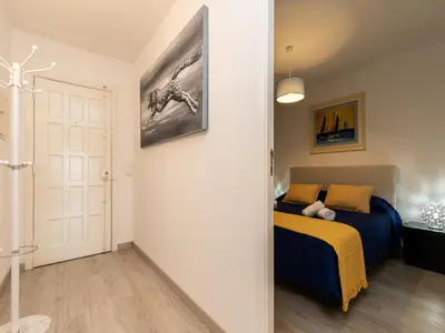 a bedroom with a bed with blue sheets and yellow pillows at Akisol Albufeira Getaway in Olhos de Água