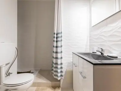 a white bathroom with a toilet and a sink at Akisol Albufeira Getaway in Olhos de Água