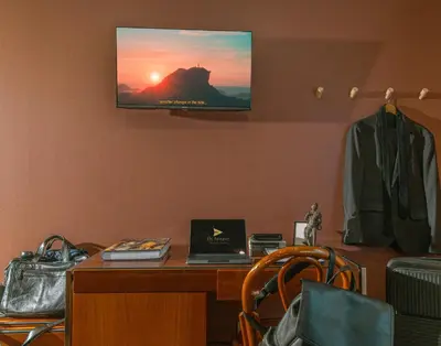 a room with a desk with a laptop and a tv on the wall at Fly House Faro in Faro