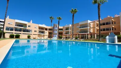 a large swimming pool in front of a building with palm trees at Marina Sol - CD 308, Cleverdetails - great location in Vilamoura