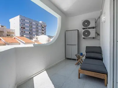 a small balcony with a couch and a window at Algarsol 1bdr apartment near the beach in Quarteira