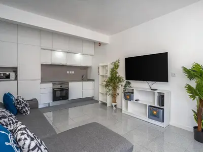 a living room with a flat screen tv on a wall at Algarsol 1bdr apartment near the beach in Quarteira