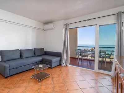 a living room with a couch and a view of the ocean at T1 com Varanda e vista mar a 200m da Praia in Quarteira