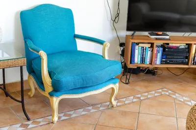 a blue chair sitting in a living room with a tv at Charming Villa with Private Pool by LovelyStay in Albufeira