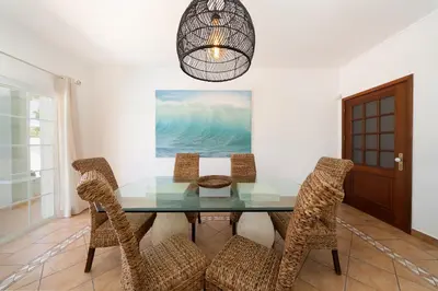 a dining room with a glass table and chairs at Charming Villa with Private Pool by LovelyStay in Albufeira
