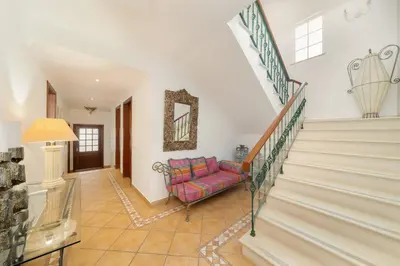 a living room with a staircase and a pink couch at Charming Villa with Private Pool by LovelyStay in Albufeira