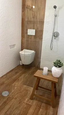 a bathroom with a shower and a toilet and a table at Oura beach & sun in Albufeira