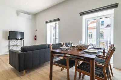 a living room with a table and a couch at Downtown 1 Bedroom Apartment E - 150m from the Beach in Albufeira