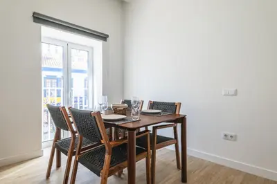 a dining room with a table with chairs and a window at Downtown 1 Bedroom Apartment E - 150m from the Beach in Albufeira