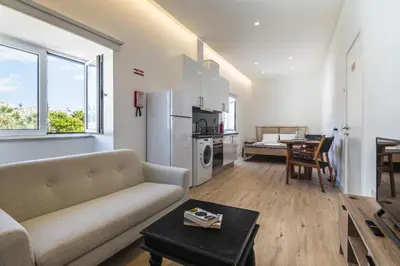 a living room with a couch and a table at Downtown Studio Apartment G - 150m from the Beach in Albufeira