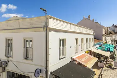 a white building with a sign on the side of it at Downtown Studio Apartment G - 150m from the Beach in Albufeira