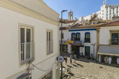 a group of people walking down a street between two buildings at Downtown Studio Apartment G - 150m from the Beach in Albufeira