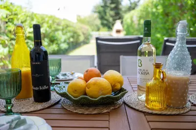 a table with bottles of wine and a bowl of fruit at Sunset Villa No 19 in Galé
