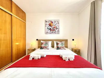 a bedroom with a large bed with a red blanket at Albufeira Amazing View With Pool by Homing in Albufeira