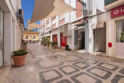 a tall pink building with balconies in a city at Faro Downtown Suites - Vila Adentro in Faro
