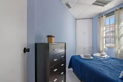 a bedroom with a bed and a dresser and a window at Faro Downtown Suites - Vila Adentro in Faro