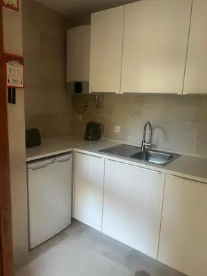 a kitchen with white cabinets and a sink at Casa Altair in Quarteira