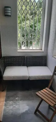 a bench in a room with a window and a chair at Casa Altair in Quarteira