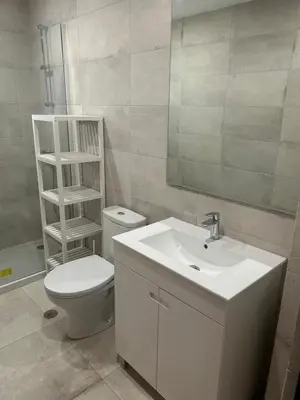 a bathroom with a sink and a toilet and a mirror at Casa Altair in Quarteira