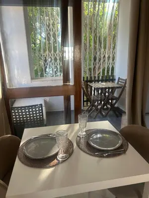a white table with two plates and glasses on it at Casa Altair in Quarteira