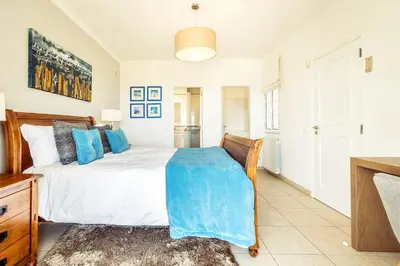 a bedroom with a bed with a blue blanket on it at Lovely Very Private Villa with Beautiful Gardens in Guia