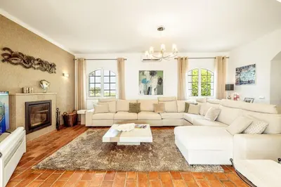 a living room with white furniture and a fireplace at Lovely Very Private Villa with Beautiful Gardens in Guia