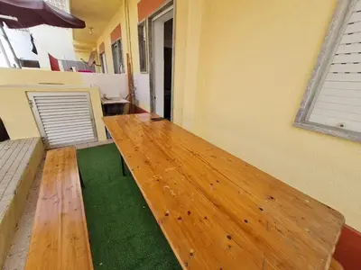 a wooden bench in a room with green carpet at T2 Praia de Faro in Faro