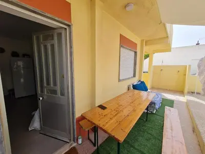 a bedroom with a bed and a chair and a blackboard at T2 Praia de Faro in Faro