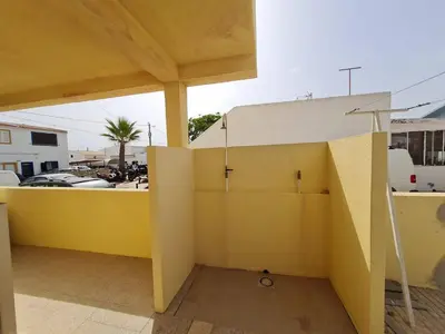 a room with a wooden table in a house at T2 Praia de Faro in Faro