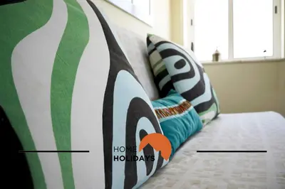 a room with a couch with a bed with pillows at #320 Quinta da Correeira 55 by Home Holidays in Vale de Pedras