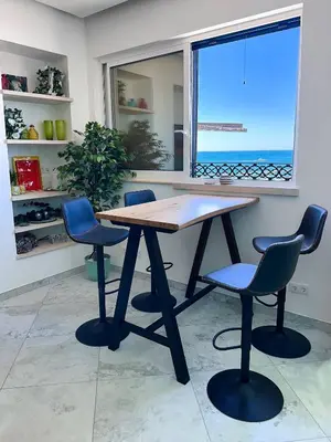 a wooden table with four chairs and a window at Luxury Beach House - Casa do Farol by BeCherish in Albufeira