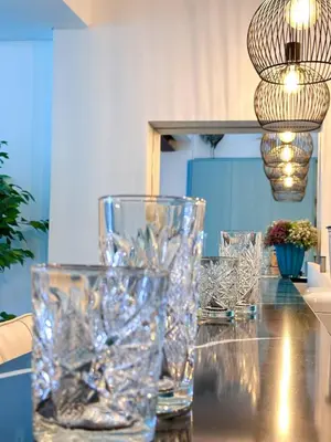a table with glasses on it with a chandelier at Luxury Beach House - Casa do Farol by BeCherish in Albufeira