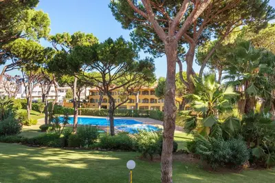 a resort with a swimming pool and trees at Sol Nascente 2_vilamoura in Quarteira