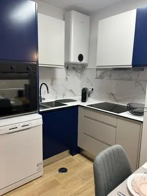 a kitchen with white and blue cabinets and a sink at Charmoso T1 Varandas de Malpique in Albufeira