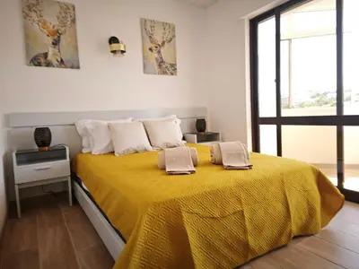 a bedroom with a yellow bed with two towels on it at Charmoso T1 Varandas de Malpique in Albufeira