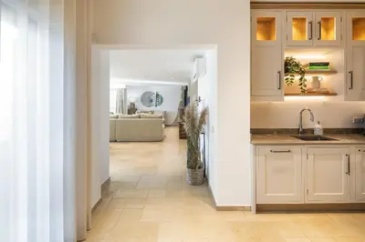 a kitchen with white cabinets and a vase of flowers at Villa Avalon - Bedzy Luxury in Almancil