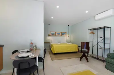 a living room with a dining table and a bedroom at Excelente Studio in Loulé
