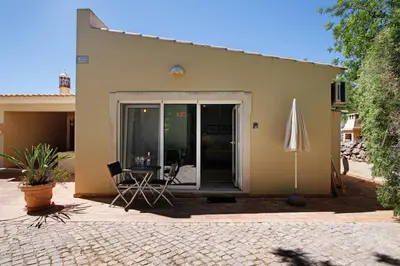 a house with a patio and an umbrella at Excelente Studio in Loulé