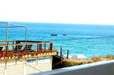 a building with flowers on a balcony overlooking the ocean at Encanto da Ria in Faro